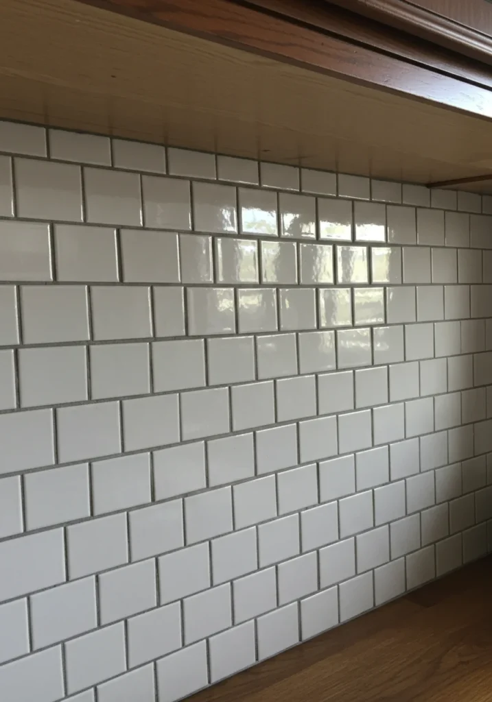 Classic white penny tile backsplash with grout lines creating a charming, timeless look.